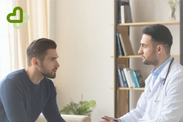 Мужчина сидит на приеме у врача